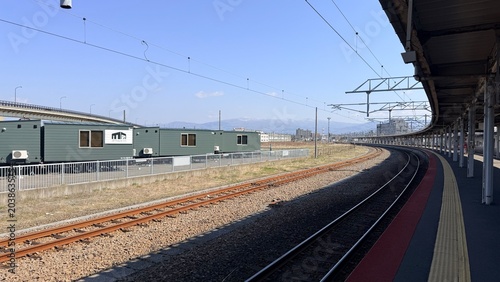 Scenic view of an empty railroad platform and tracks at a remote countryside station in Hokkaido.