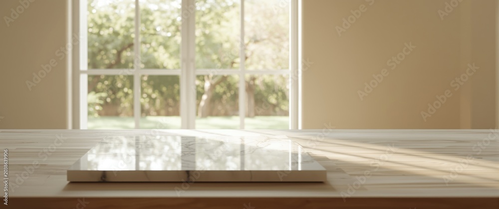 Fototapeta premium Elegant white stone marble surface on table with unclear interior and garden view through large window for layouts