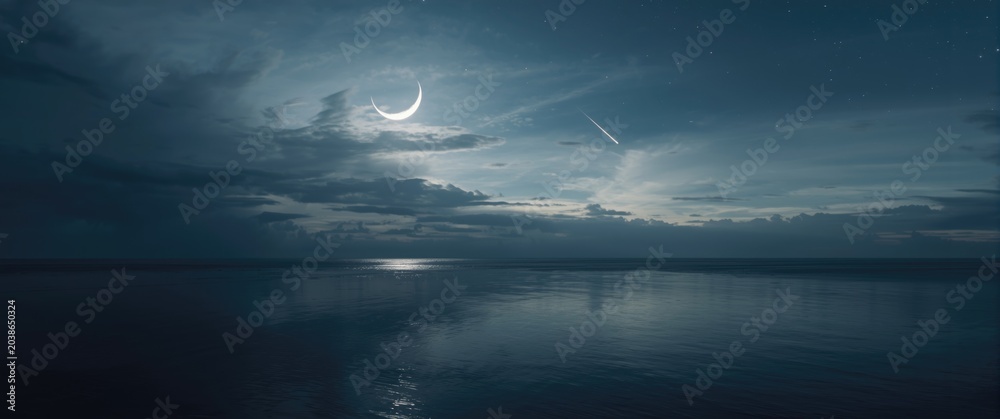 Obraz premium Crescent moon and shooting star reflected on calm sea under a cloud filled sky