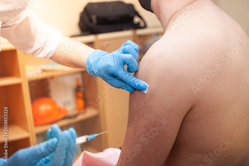 Tableau sur toile Nurse holding vaccination against covid-19 in male hand