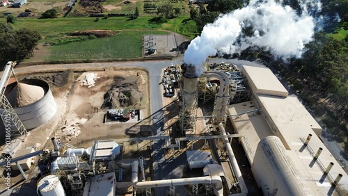 Fotografi Industrial factory producing smoke from tall chimney
