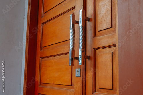 Fotografie A detailed shot focusing on the polished chrome handles of a solid, warm-toned w