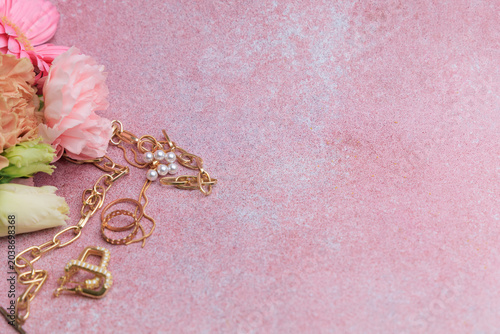 Картината върху платно Jewelry and flowers on a pink background during daytime showcasing an elegant ar
