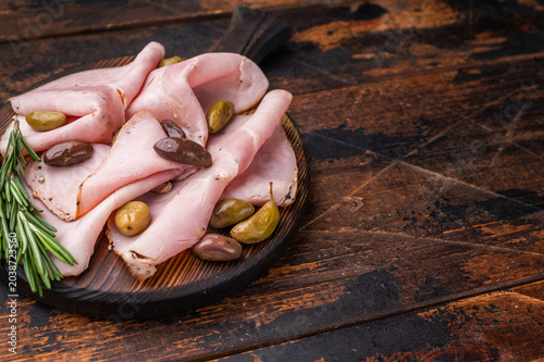 Fotografie Italian cured meat slices spalla with olives and rosemary on wooden serving board forming a practical background for culinary advertising