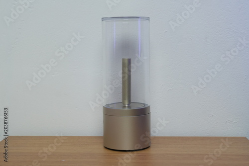 Modern minimalist glass tube speaker and ambient light device on a wooden table