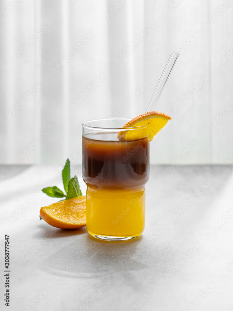 Fototapeta premium Cold bumble coffee with orange juice and ice on light background