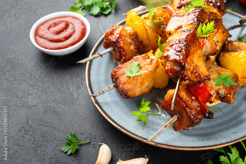 Fotografi Grilled shish kebab, Grilled meat skewers with vegetables and herbs on black background