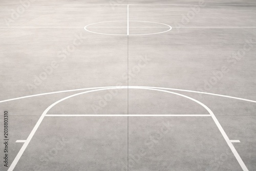 High angle view of white lines painted on a grey concrete basketball court outdoor.