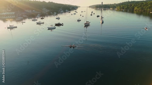 In the calm waters of Halifax Ocean Bay, a team of spirited young women skillfully navigates their two-seater rowing boat. They demonstrate teamwork and dedication under the warm sun