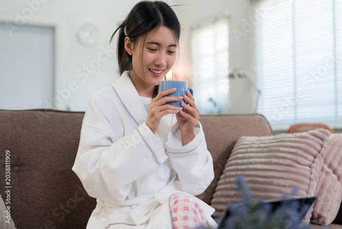 Картината върху платно young Asian woman enjoying morning routine drinking hot coffee tea beverage wear