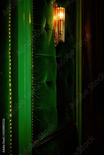 Luxurious Emerald Green Velvet Upholstery with Stud Detail and Modern Wall Sconce