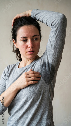Young woman suffering from excessive sweating hyperhidrosis and body odor looking concerned