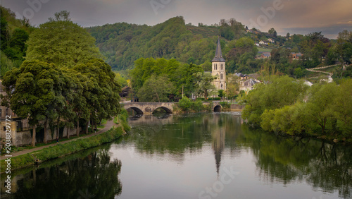 Aerial view of the Meuse river flowing past the historic town center with the Collegiate Church spire and lush green hills Dinant, Wallonia, Belgium.