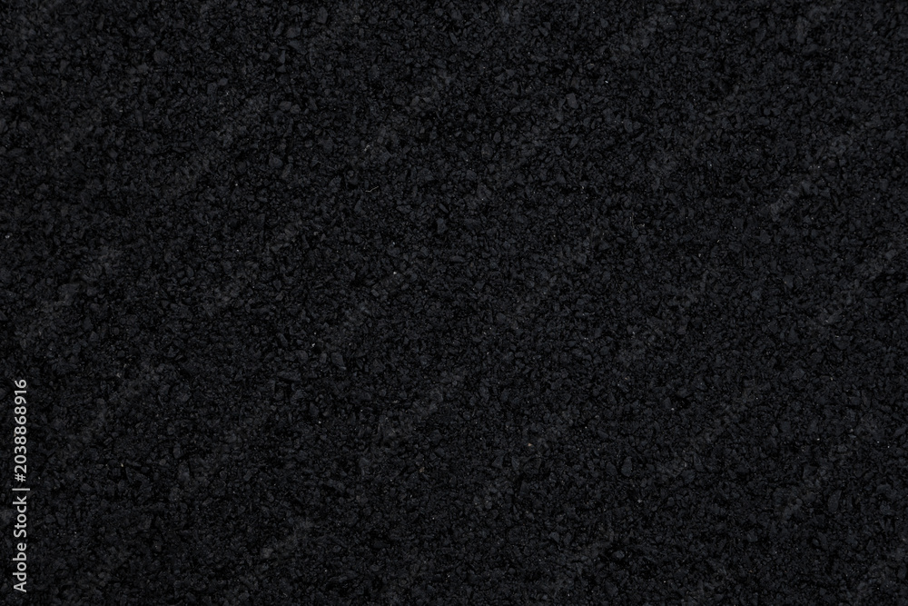 Fototapeta premium The background image shows a freshly laid asphalt surface, just a few hours old, with a clear, almost completely black texture.