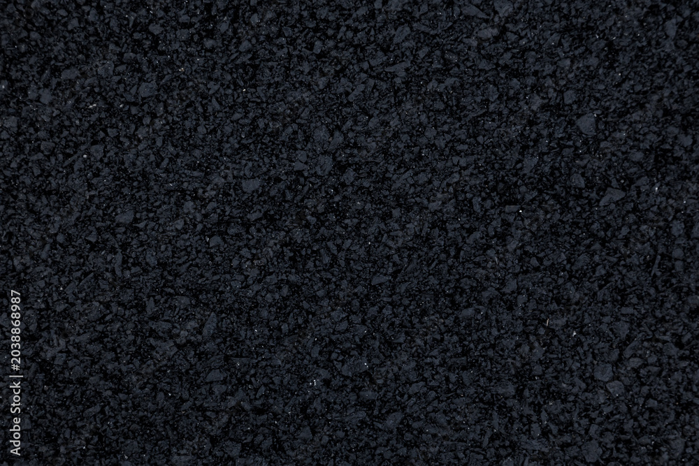 Fototapeta premium The background image shows a freshly laid asphalt surface, just a few hours old, with a clear, almost completely black texture.