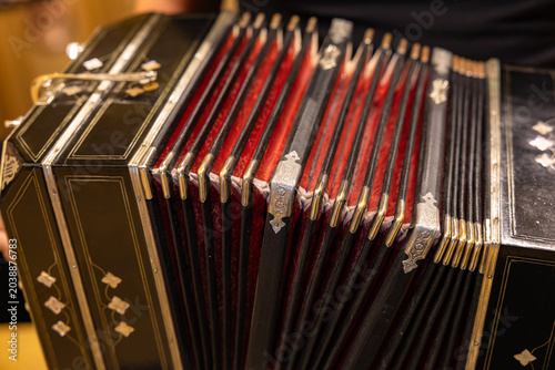 Fotografía Close up of vintage black bandoneon accordion bellows with red fabric