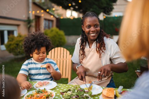 Multi-ethnic family members enjoying happy outdoor garden dinner