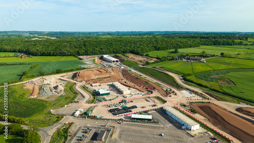 Aerial view of HS2 High Speed Rail Civil Engineering Works with earthworks, machinery, and temporary site buildings surrounded by green fields Southam, England, United Kingdom.