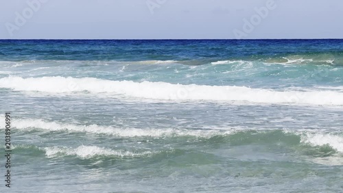 The restless sea changes its color as the waves roll in. High quality 4k footage
