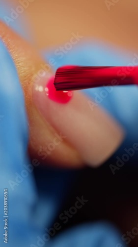 Close up of nail technician painting female nails with pink polish during professional manicure procedure for beauty wellness and elegant appearance. High quality 4k footage