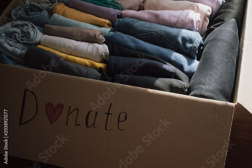 Fotografía Box of neatly folded clothes ready for donation at home, highlighting generosity