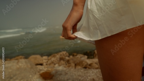 Authentic warm weather snapshot capturing person near rough coastal stones