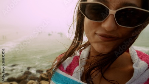 Relaxed female traveler documenting warm sunny day by rocky shoreline