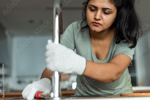 Photography Focused woman fixing sink photo