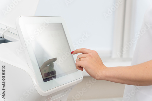 hand with red nails operating a touchscreen interface