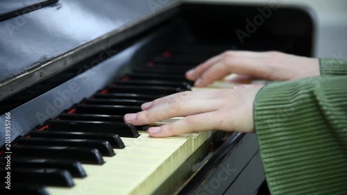 female pianist hands on black and white piano keyboard, close-up view, young woman playing piano, professional musician