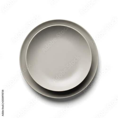 Two empty matte grey ceramic plates stacked perfectly centered on a clean white background viewed from a top down perspective