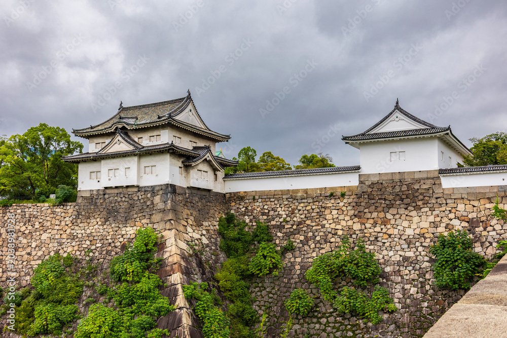Naklejka premium Elevated stone embankment surrounding Osaka Castle in Osaka Japan during calm overcast weather, Osaka Japan