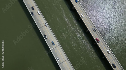 Vertical drone view of the Chesapeake Bay Bridge in Maryland, showing two-way traffic flowing in opposite directions as vehicles cross the span over the Chesapeake Bay