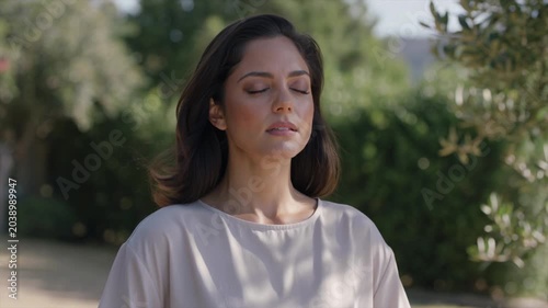 Peaceful woman practicing mindful breathing outdoors in nature