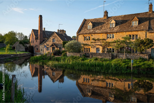 Canvastavla Traditional Cotswolds stone village with watermill and river reflection at sunse