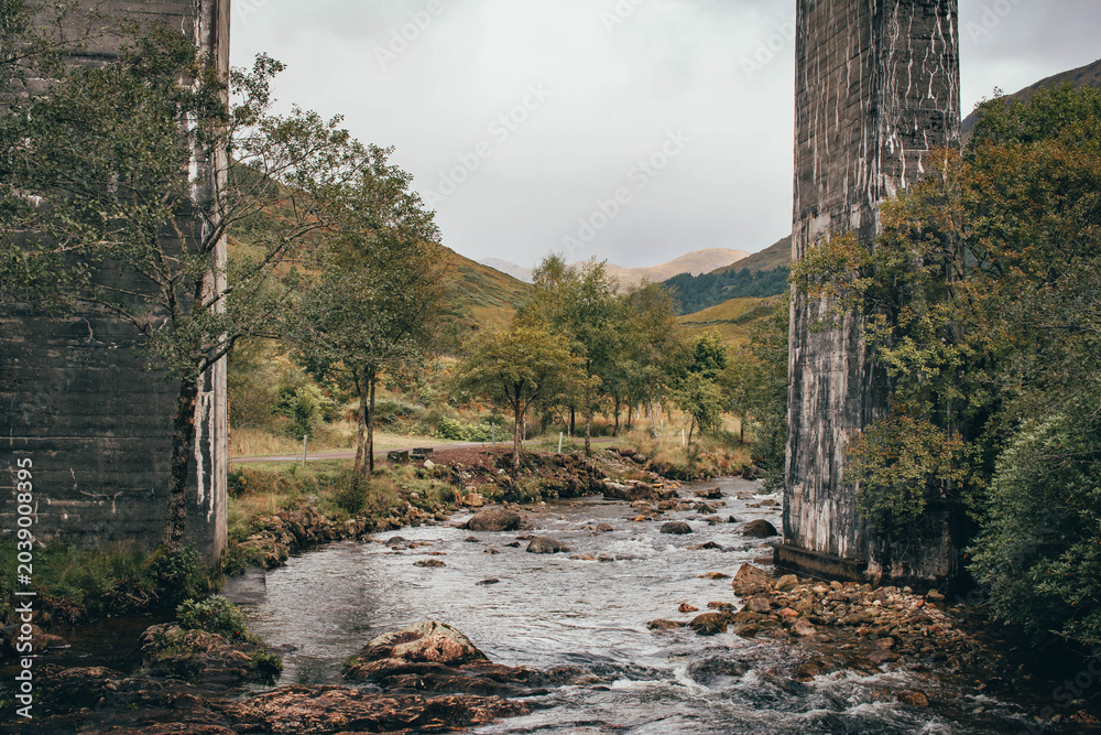 Naklejka premium The historic Glenfinnan Viaduct surrounded by lush green hills, Scottish Highlands