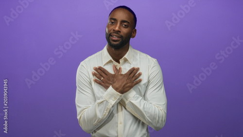 Quadro em tela Man with hands crossed over chest in purple studio wearing white shirt and ring; gratitude sincerity warmth