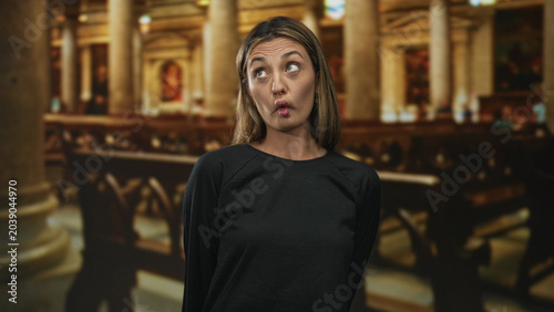Konstfotografi Woman smiling with puckered lips and warm expression inside a historic church building; playful reflection