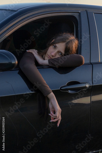 фотографія Kyiv/Ukraine/05/29/2026Young woman leaving car window with melancholic expressio