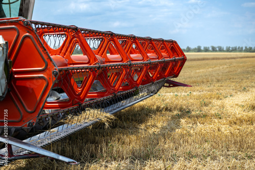Foto Close-up view of a large orange combine harvester reel actively working in a dry