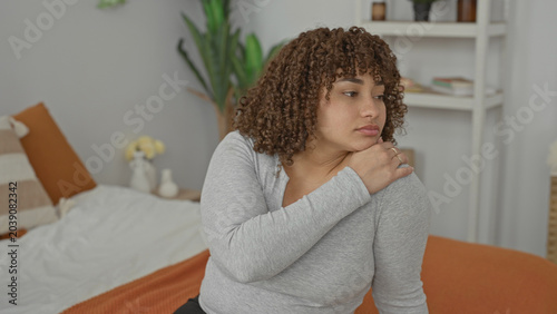 Tableau sur toile Woman on bed touching shoulder while another woman sits with arms crossed in building; tension estrangement