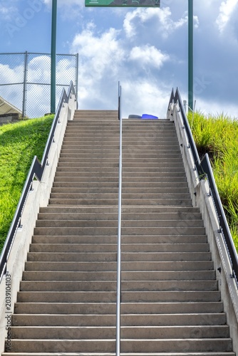 Concrete staircase with metal railings, and green grass on the sides