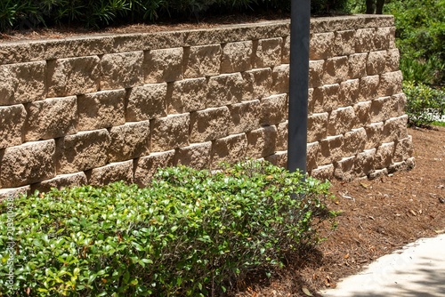 Fotografía Stone retaining wall sorrounded with bushes