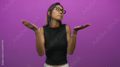 Εκτύπωση καμβά Thai woman with glasses and bare forearms plugging her ears with fingers and shrugging in studio amid purple backdrop; annoyance boundaries