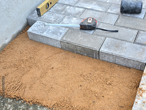 Close-up of a builder installing and laying paving stones on a terrace
