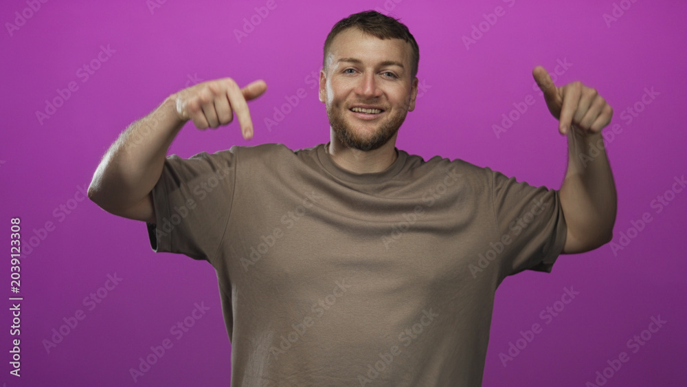 Fototapeta premium Man pointing fingers down with bare hands in studio against purple backdrop; confidence promotion announcement.