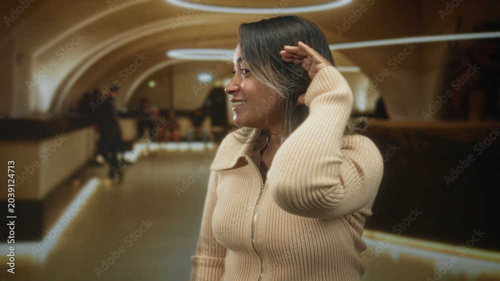 Fototapeta premium Hispanic woman shading eyes with hand at hotel reception counter wearing beige zip sweater and necklace; calm travel.