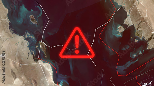 Satellite view of the Strait of Hormuz with a red warning symbol and digital lines. Concept of geopolitical tension, oil supply risks, maritime security, and global trade instability in the Gulf.