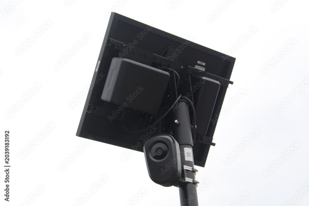 Obraz premium Low-angle close-up photograph of a solar-powered surveillance camera mounted on a metal pole.