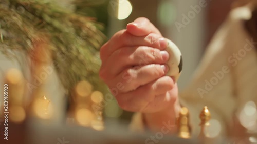 Close up hands gripping stress ball beside chess pieces on tabletop, warm cafe lights and shallow bokeh, firm clasp and subtle tremor, strategy pause before move, golden pieces and blurred background